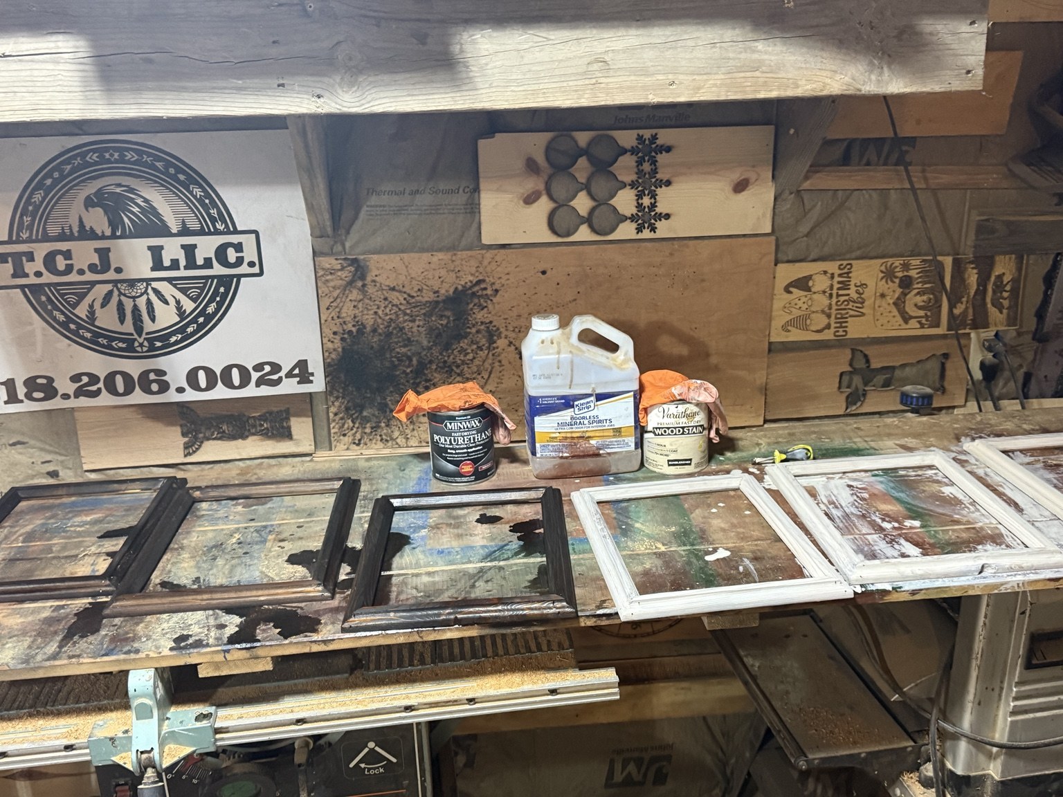 Dark and light wooden frames beside wood stain and polyurethane in Tim’s workshop